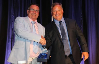 New USAPEEC Chairman Marc Killebrew of Tyson Foods, right, receives the ceremonial gavel from outgoing Chairman Steve Monroe of Sanderson Farms. | USAPEEC