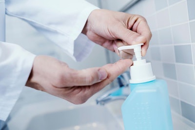 closeup of a caucasian doctor man, in a white coat, disinfecting