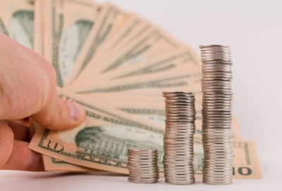 a money coins in columns with dollar bills on a white background