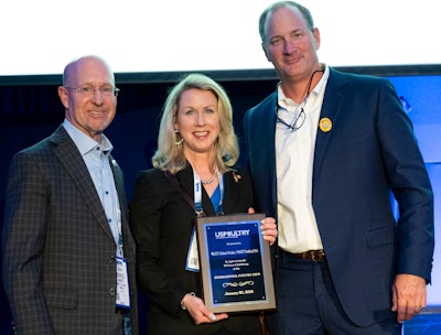 Greg Watt and Nancy Batio from WATT Global Media accept the long-time exhibitor plaque from Mikell Fries (right), Claxton Poultry Farms and USPOULTRY chair.