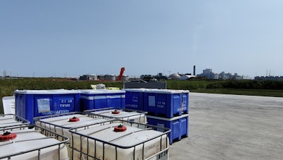 Dry and wet corn byproduct containers outside Innovafeed’s pilot facility in Decatur, Illinois, within sight of an ADM wet corn processing facility.