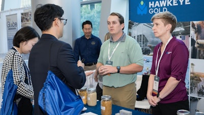 Survey results from Export Exchange 2024 show 968,030 metric tons of U.S. agricultural products were sold during or immediately after the event. Pictured, attendees speak with representatives from U.S. Grains Council member Hawkeye Gold about its products and services.
