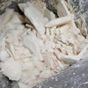 Crumpled white clay or plaster material with textured, uneven surface