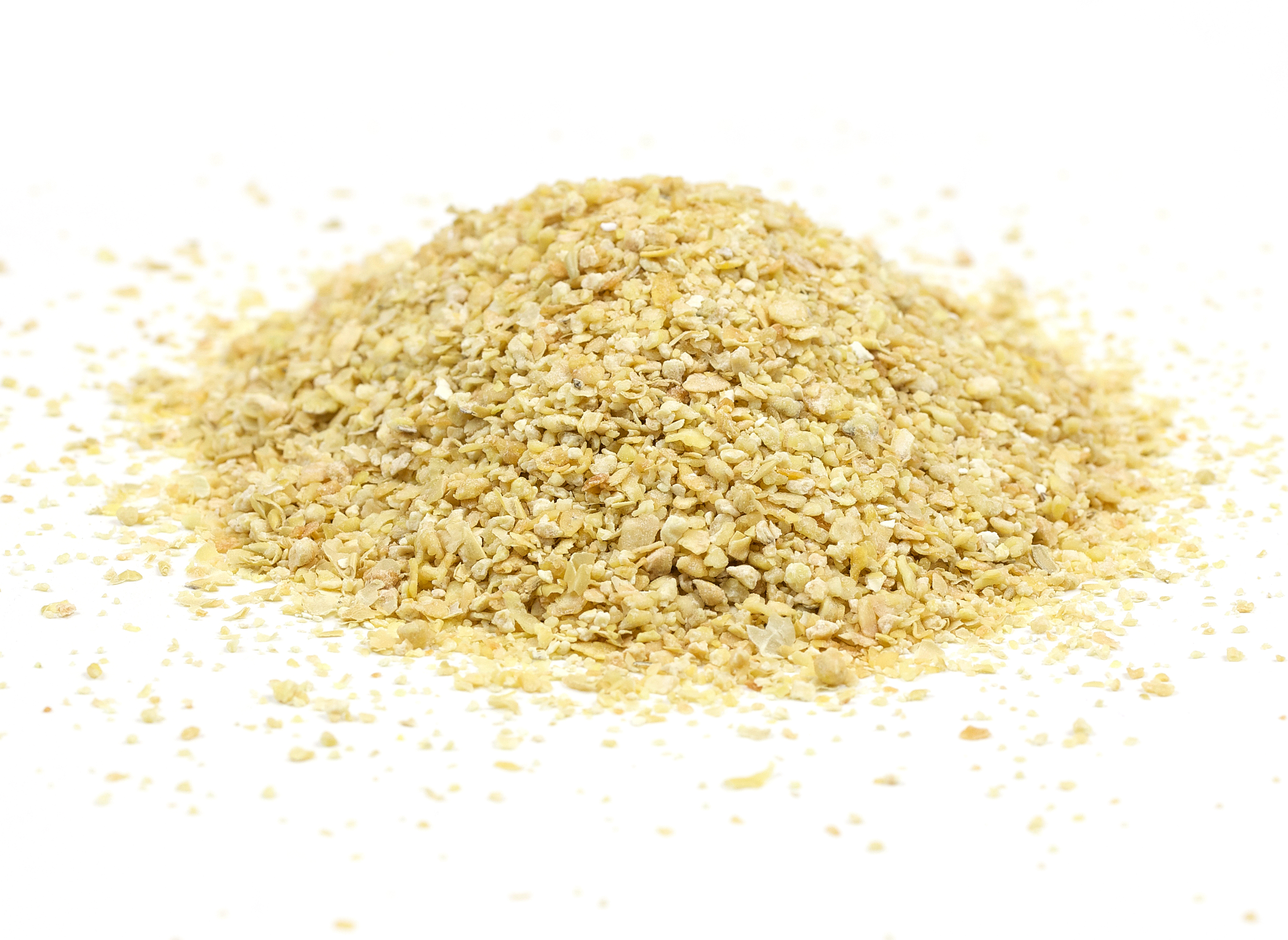 Pile of golden sesame seeds scattered on white background