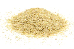 Pile of golden sesame seeds scattered on white background