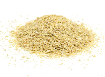 Pile of golden sesame seeds scattered on white background