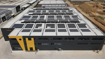 Industrial building with solar panels on roof, black and yellow exterior