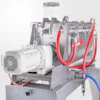 Industrial machinery with electric motor, metal processing unit, and red and blue hoses