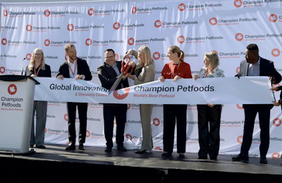 Champion Petfoods Global Innovation Discovery Center ribbon-cutting ceremony with executives and officials on stage