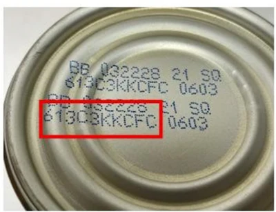 Close-up of printed batch codes and manufacturing information on metal can lid