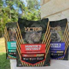 Three Victor Super Premium cat food bags featuring Hunter's Instinct formula with salmon recipe displayed outdoors