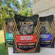 Three Victor Super Premium cat food bags featuring Hunter's Instinct formula with salmon recipe displayed outdoors