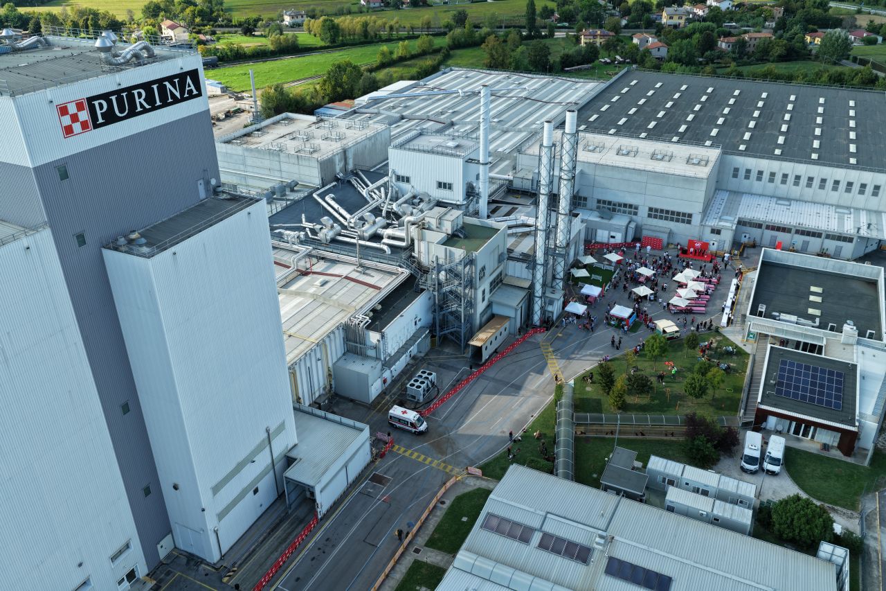 Aerial view of Purina manufacturing facility with multiple industrial buildings, parking areas, and surrounding green landscape