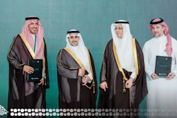 Four men in traditional Saudi Arabian formal attire posing together against a turquoise background