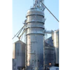 Industrial grain elevator with cylindrical metal silos and conveyor systems under clear blue sky