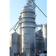 Industrial grain elevator with cylindrical metal silos and conveyor systems under clear blue sky