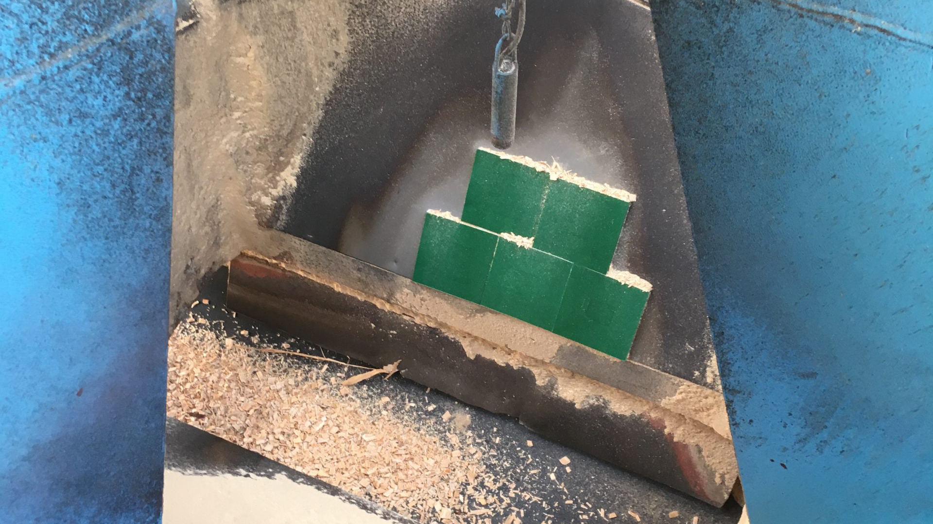 Green tiles stacked in weathered concrete container against blue wall
