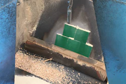 Green tiles stacked in weathered concrete container against blue wall