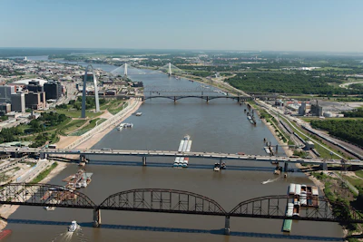 Aerial view of Detroit skyline with multiple bridges crossing the Detroit River, showing urban development and waterfront infrastructure.