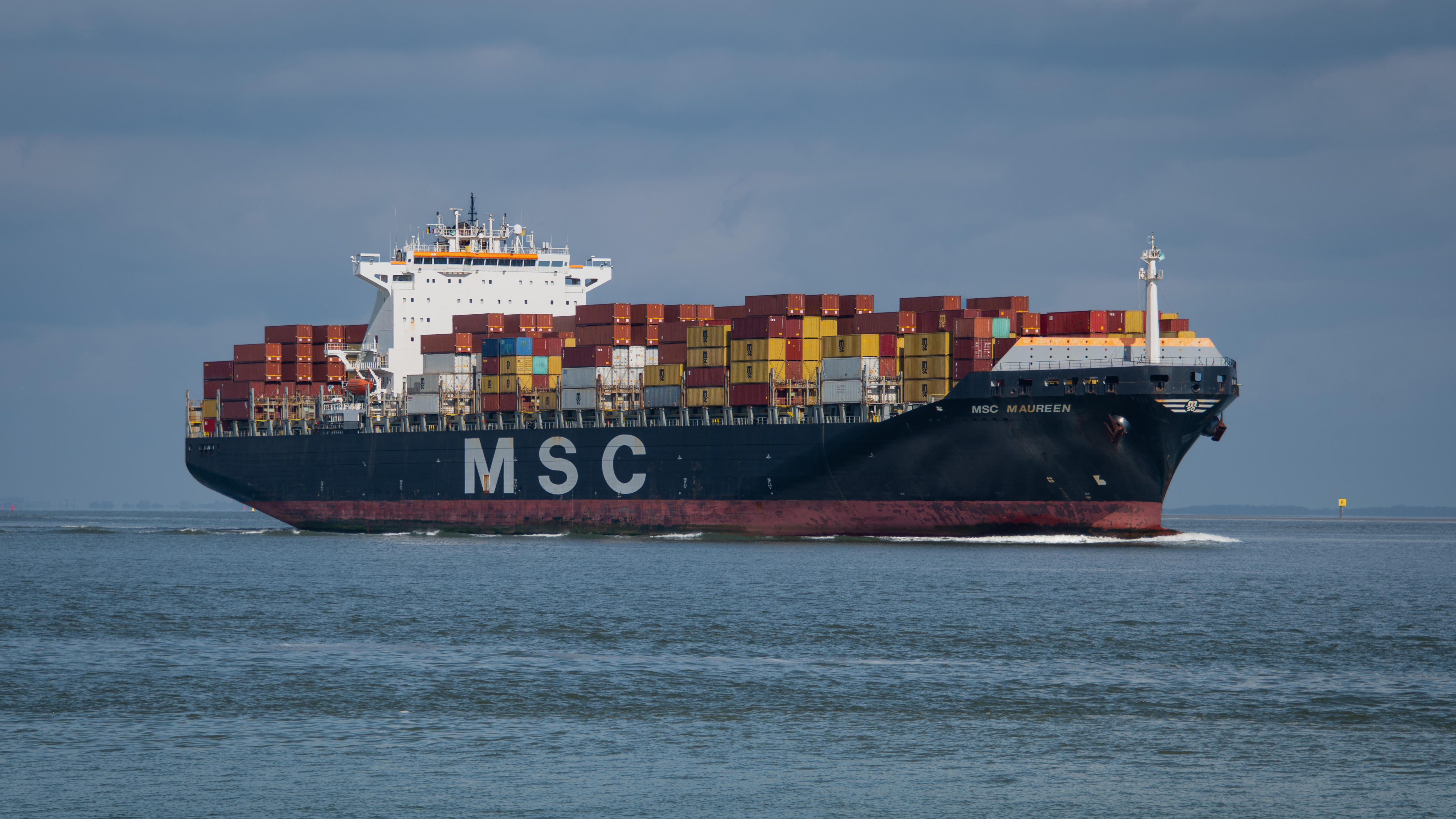 MSC container ship loaded with colorful cargo containers sailing on calm blue ocean waters