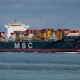 MSC container ship loaded with colorful cargo containers sailing on calm blue ocean waters