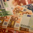Scattered Euro banknotes in various denominations including €10, €20, €50, and €100 notes displayed on a surface