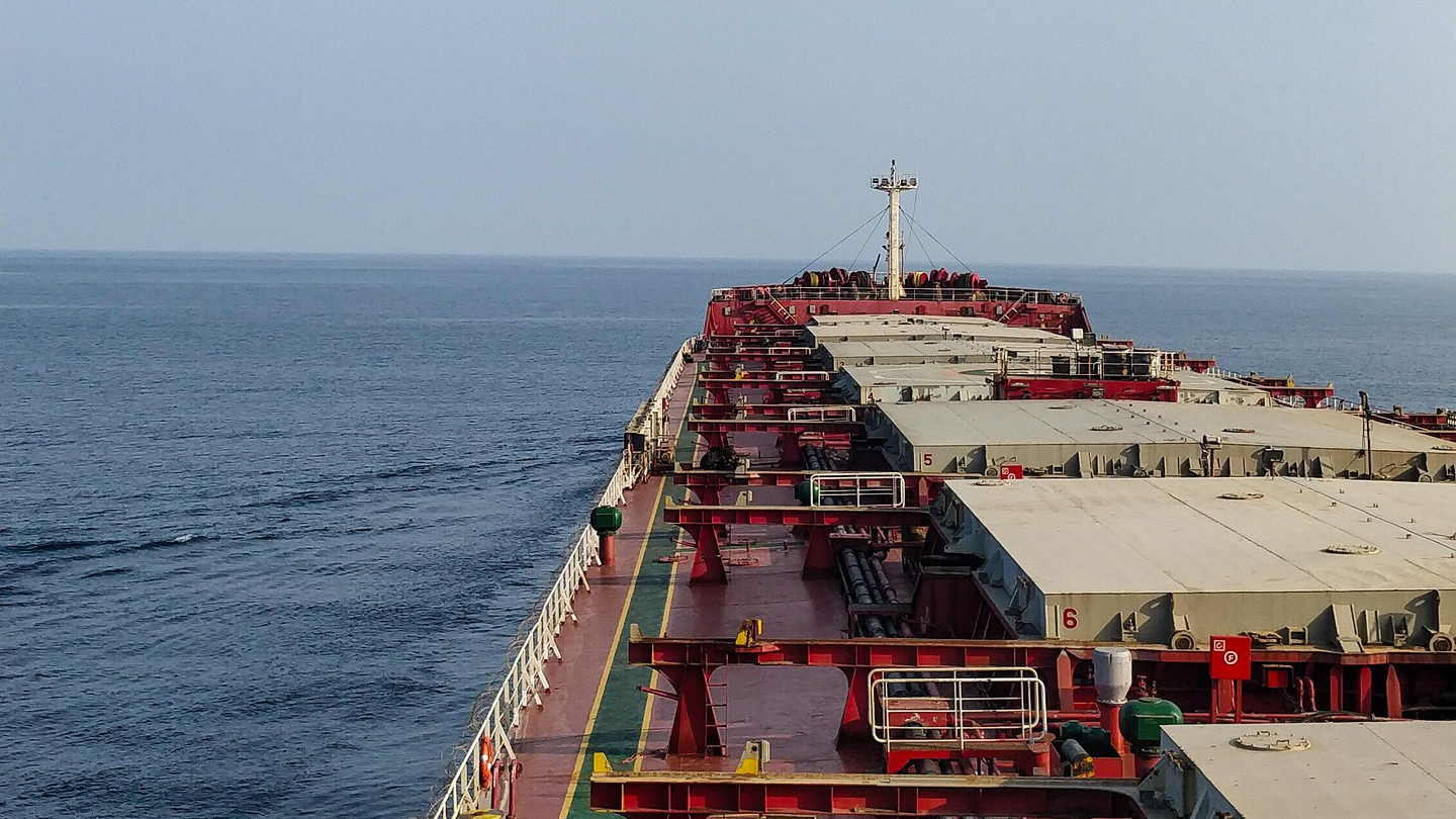 Large red and white oil tanker ship sailing on open ocean water