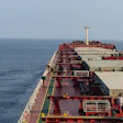 Large red and white oil tanker ship sailing on open ocean water