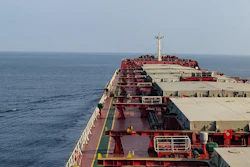 Large red and white cargo tanker ship at sea with deck infrastructure and navigation equipment visible