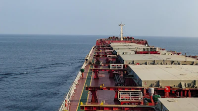 Large red and white cargo tanker ship at sea with deck infrastructure and navigation equipment visible