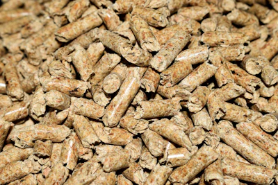 Close-up of tan and brown wood pellets or biomass fuel material with natural texture
