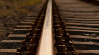 Close-up view of railroad tracks with wooden ties and metal rails converging toward the horizon