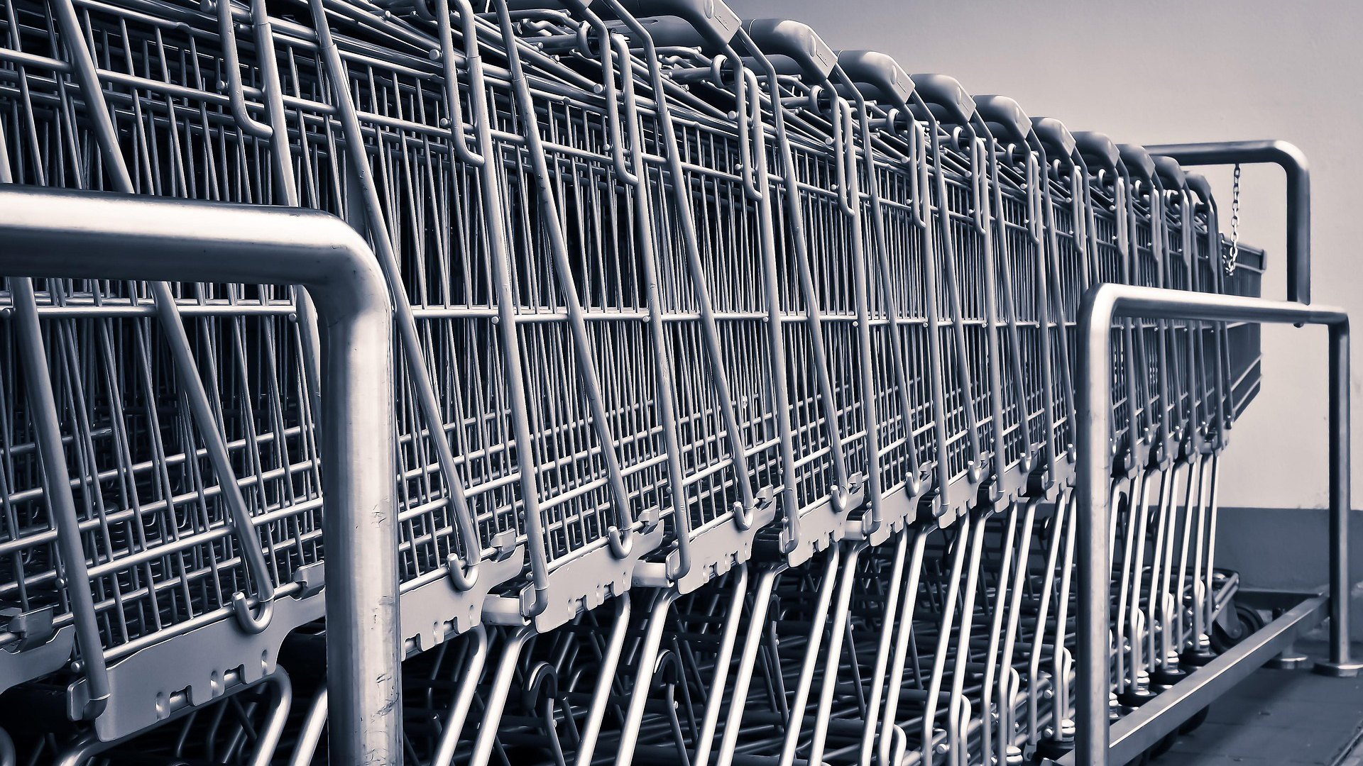 Row of stacked metal shopping carts lined up in a parking lot or storage area