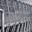 Row of stacked metal shopping carts lined up in a parking lot or storage area