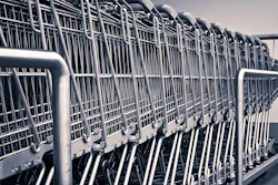 Row of stacked metal shopping carts lined up in a parking lot or storage area