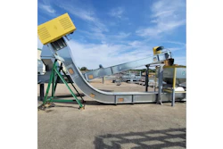 Industrial concrete mixer and conveyor system with yellow hopper and green support frame at outdoor facility