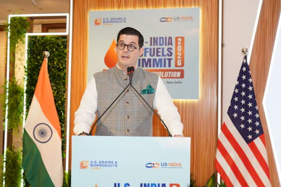 Speaker at India Fuels Summit 2026 event podium with U.S. and Indian flags and organizational branding backdrop